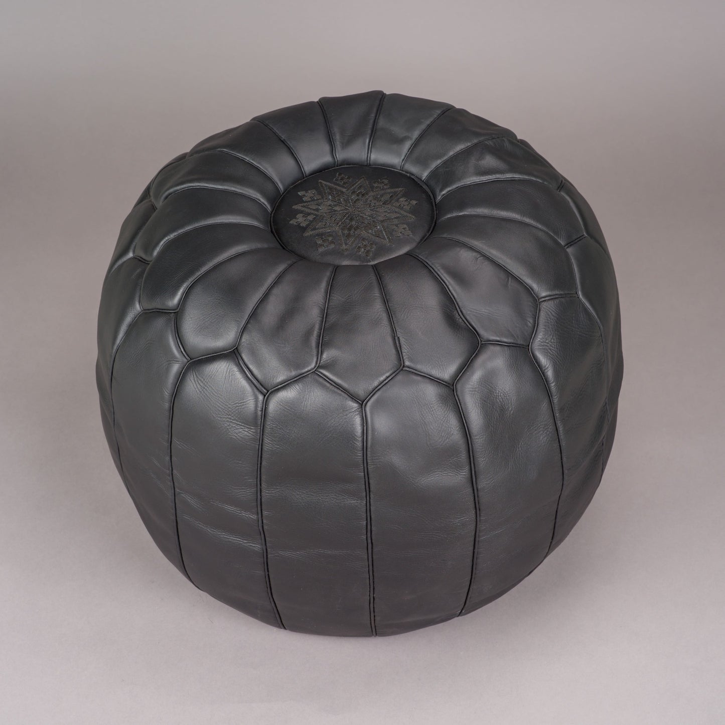 Svart sittpuff av skinn